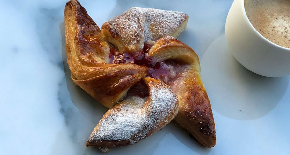 close up of pastry on a plate with a coffee